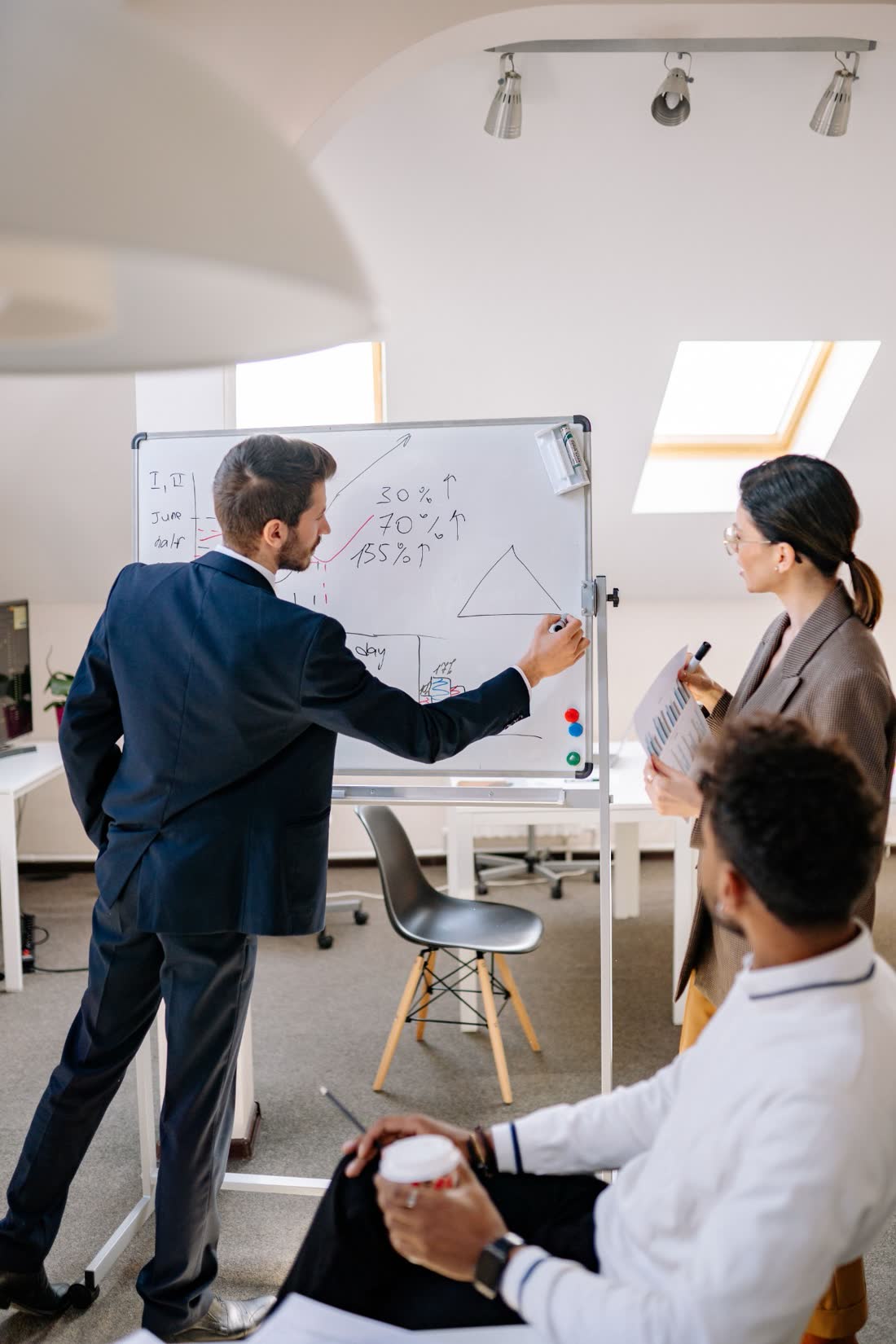 A team working through numbers at a whiteboard